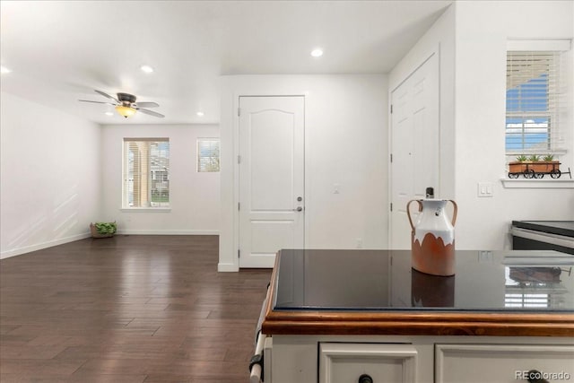 interior space featuring a ceiling fan, baseboards, recessed lighting, and dark wood-style floors