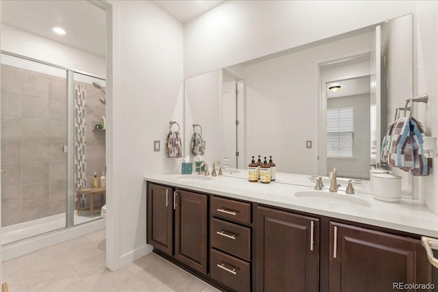 bathroom with a stall shower, toilet, a sink, tile patterned floors, and double vanity