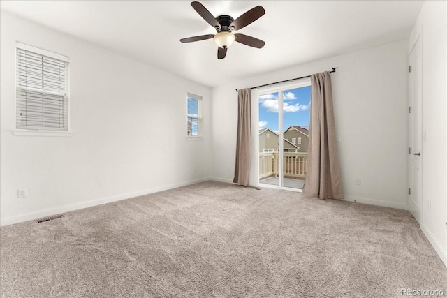 spare room with a ceiling fan, carpet flooring, visible vents, and baseboards