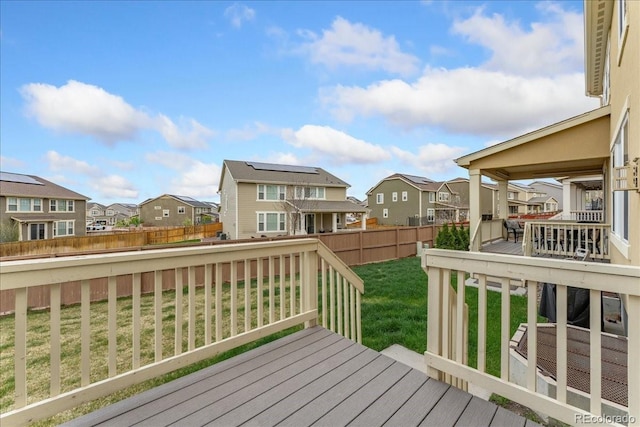 wooden deck featuring a yard, a residential view, and a fenced backyard