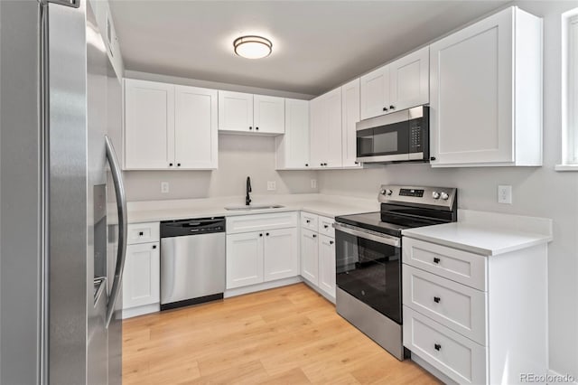 6800 E Tennessee Ave Unit 541, Denver, CO 80224 - kitchen featuring appliances with stainless steel finishes, a sink, light wood finished floors, and white cabinets