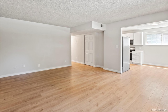 6800 E Tennessee Ave Unit 541, Denver, CO 80224 - unfurnished living room featuring light wood-style floors, a textured ceiling, and baseboards