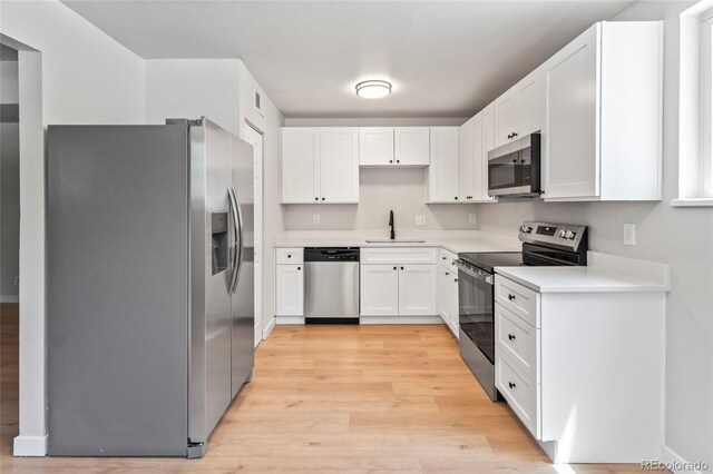 6800 E Tennessee Ave Unit 541, Denver, CO 80224 - kitchen featuring appliances with stainless steel finishes, a sink, light wood-type flooring, and white cabinetry
