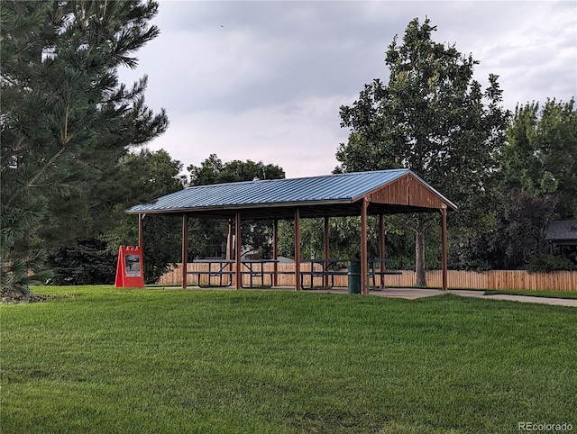 view of property's community featuring a lawn and fence