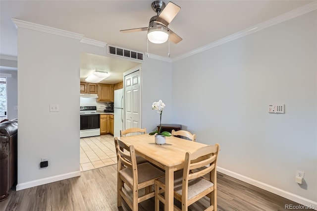 dining area featuring ceiling fan, visible vents, baseboards, light wood-style floors, and ornamental molding