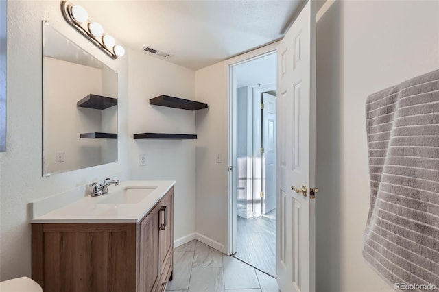 bathroom with marble finish floor, baseboards, visible vents, and vanity