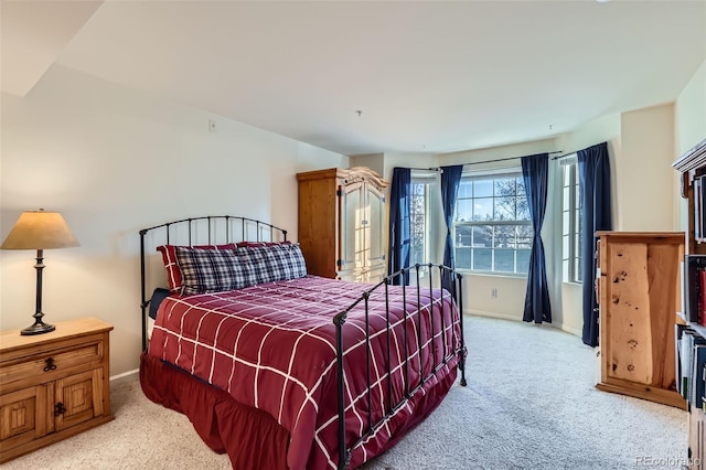 bedroom with light carpet and baseboards