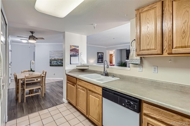 kitchen with light tile patterned floors, white dishwasher, light countertops, crown molding, and a sink