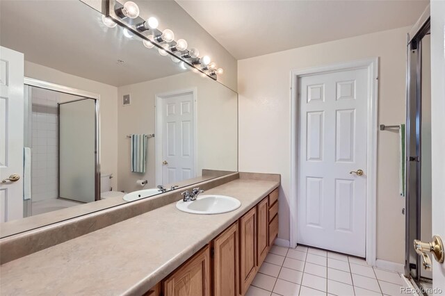 12338 W Dorado Pl Unit 107, Littleton, CO 80127 - bathroom with toilet, tile patterned flooring, vanity, and a shower with shower door