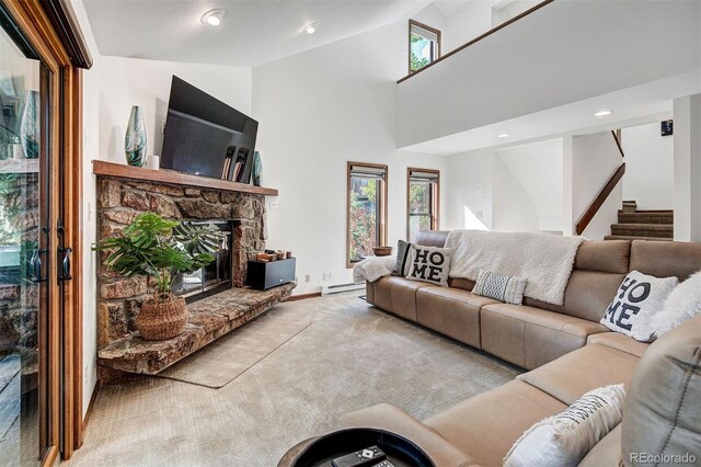 180 Nottingham Rd Unit C, Avon, CO 81620 - carpeted living room with a baseboard radiator, stairway, a fireplace, and high vaulted ceiling