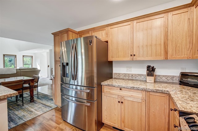 180 Nottingham Rd Unit C, Avon, CO 81620 - kitchen featuring stainless steel fridge, light wood-style flooring, light brown cabinets, open floor plan, and light stone countertops