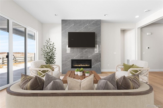living room with baseboards, a fireplace, recessed lighting, and wood finished floors