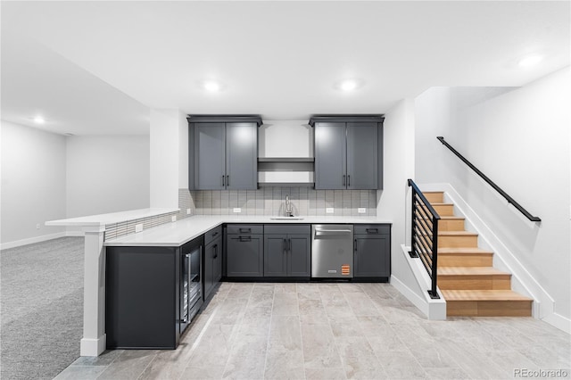 kitchen featuring light countertops, a sink, a peninsula, and dishwasher