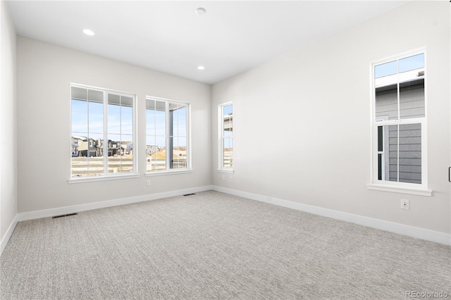 carpeted empty room featuring visible vents, recessed lighting, and baseboards