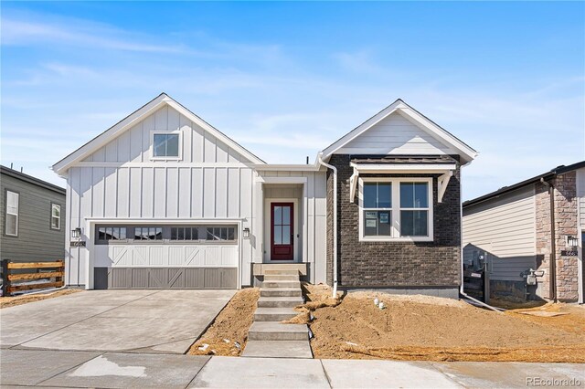 6675 Fawn Path Ln, Castle Pines, CO 80108 - view of front of home featuring concrete driveway, brick siding, board and batten siding, and a garage