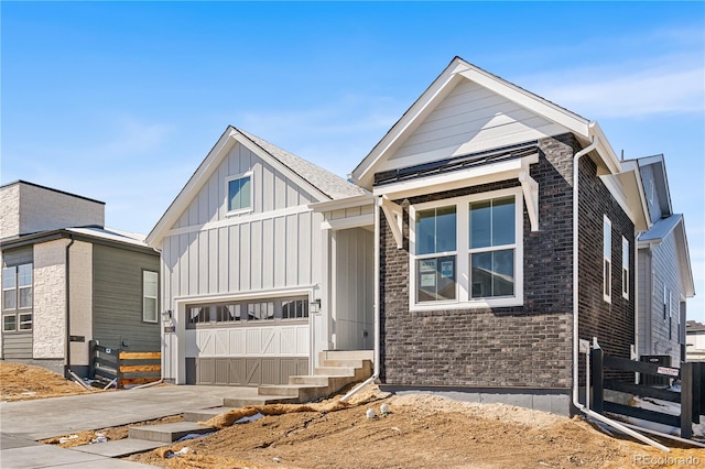 view of front of house featuring an attached garage, brick siding, board and batten siding, entry steps, and driveway
