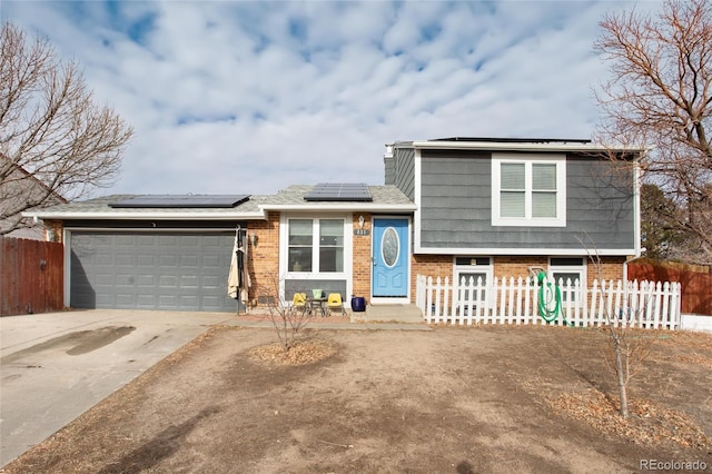 view of front of home featuring solar panels and a garage