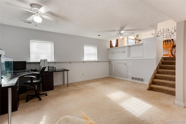 office area featuring ceiling fan, light colored carpet, and a textured ceiling