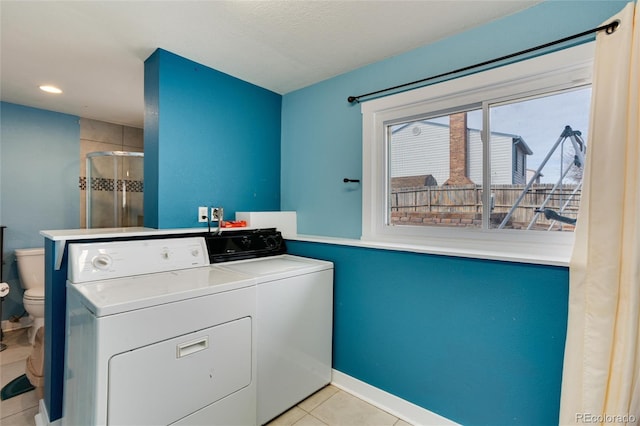 washroom featuring washing machine and clothes dryer and light tile patterned flooring