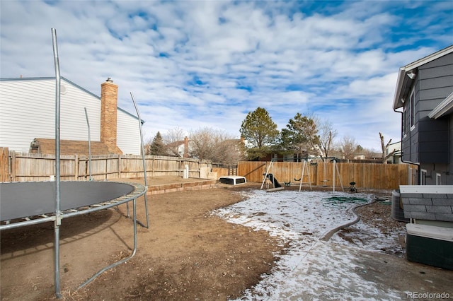 yard covered in snow with a playground, a trampoline, and central air condition unit