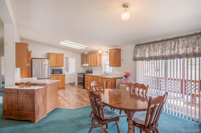 dining room with light colored carpet, sink, and lofted ceiling