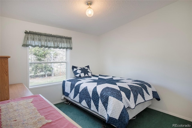 bedroom with dark colored carpet and a textured ceiling