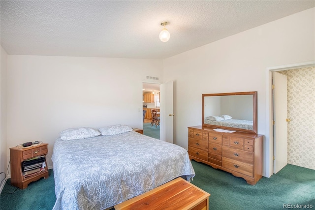 bedroom with a textured ceiling, lofted ceiling, and dark colored carpet