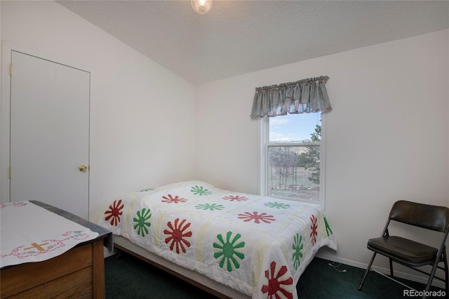 bedroom with a textured ceiling, lofted ceiling, and dark colored carpet