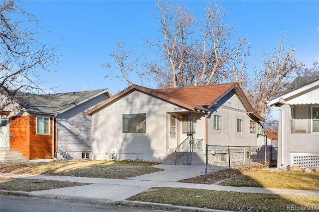 bungalow featuring driveway and fence