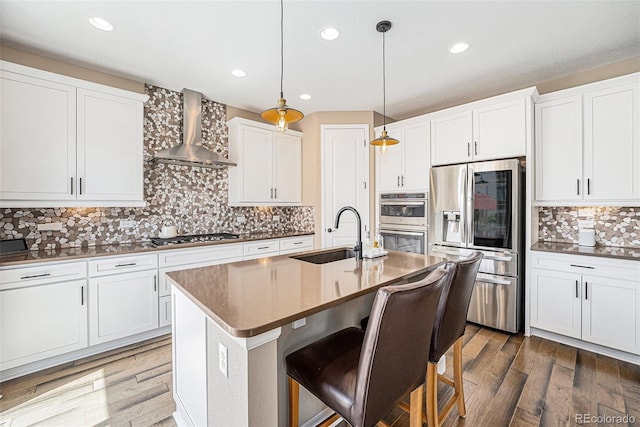 3480 Mount Powell Dr, Broomfield, CO 80023 - kitchen featuring wall chimney range hood, a sink, stainless steel appliances, recessed lighting, and backsplash