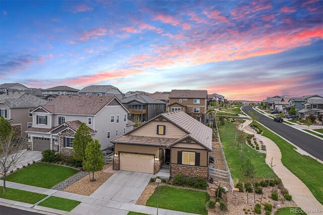3480 Mount Powell Dr, Broomfield, CO 80023 - view of front facade featuring a garage, stone siding, a yard, driveway, and a residential view