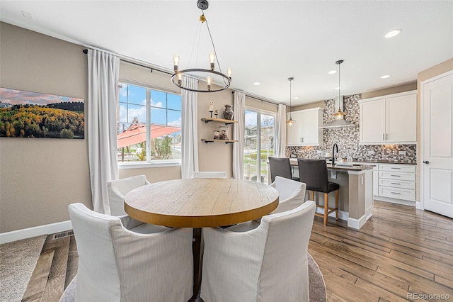 3480 Mount Powell Dr, Broomfield, CO 80023 - dining space with a chandelier, recessed lighting, baseboards, wood finished floors, and visible vents