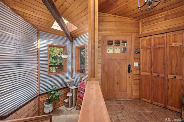 entryway featuring a skylight, wooden ceiling, and stone finish flooring