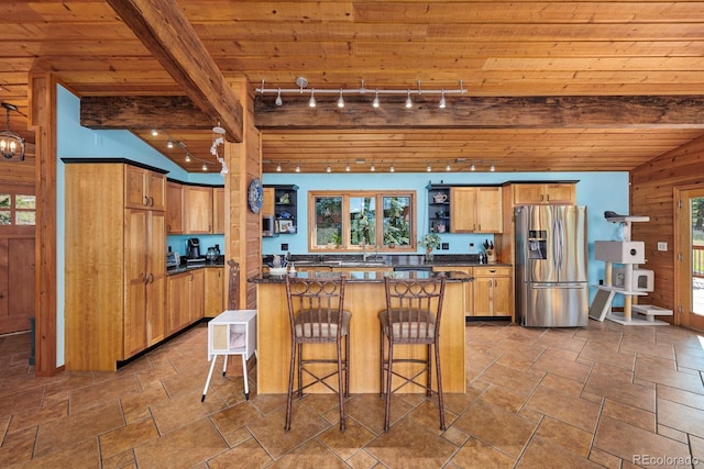 kitchen featuring lofted ceiling with beams, a peninsula, dark countertops, and stainless steel fridge with ice dispenser