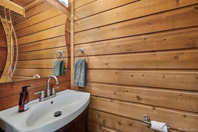 bathroom with vanity and wooden walls