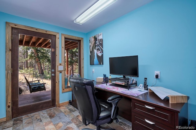 office space featuring stone finish floor and baseboards