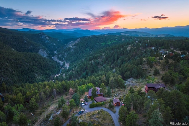 aerial view at dusk with a mountain view and a view of trees