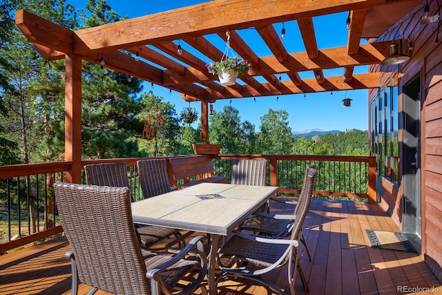 deck featuring outdoor dining space and a pergola