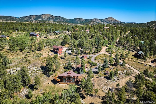 drone / aerial view featuring a forest view and a mountain view