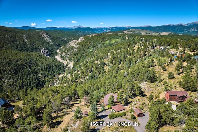 aerial view with a wooded view and a mountain view