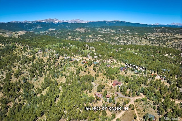 drone / aerial view with a mountain view and a view of trees