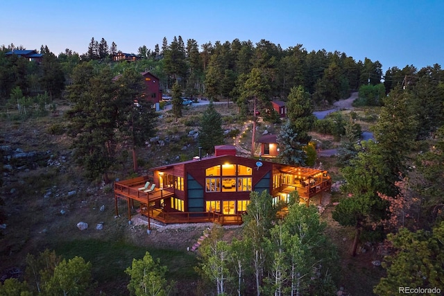 exterior space featuring a forest view and a wooden deck