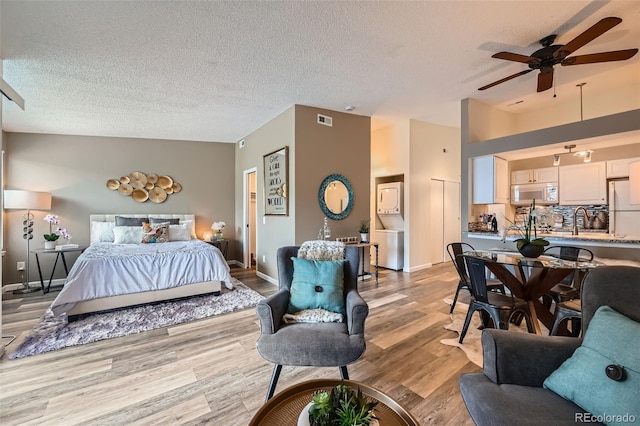 4285 S Salida Way Unit 17, Aurora, CO 80013 - bedroom featuring light wood-type flooring, freestanding refrigerator, a textured ceiling, a sink, and baseboards