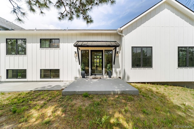 rear view of house with a patio and a lawn