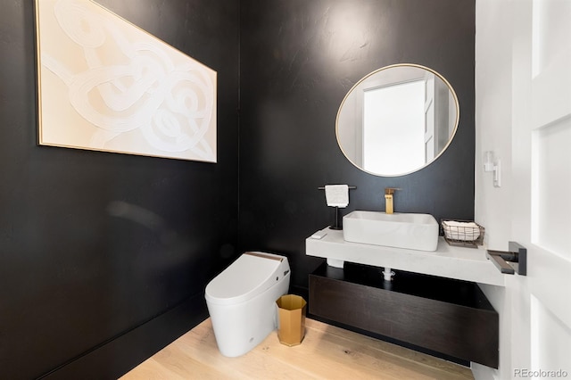 bathroom with sink, hardwood / wood-style flooring, and toilet