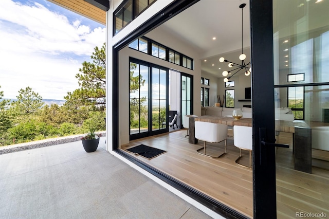 interior space with an inviting chandelier, a towering ceiling, and hardwood / wood-style floors