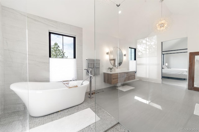 bathroom featuring a bathing tub, a towering ceiling, tile walls, vanity, and tile patterned floors