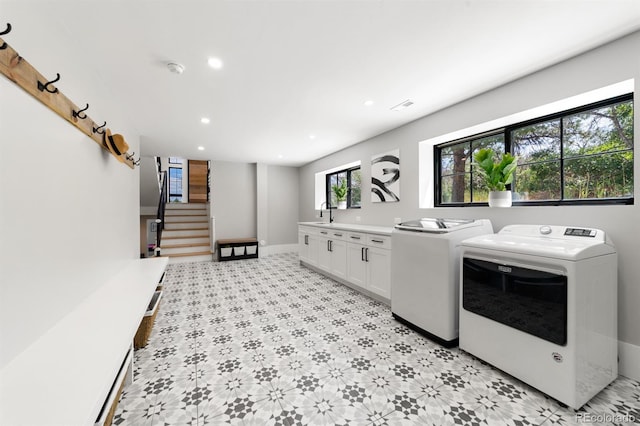 washroom with washer and clothes dryer and cabinets