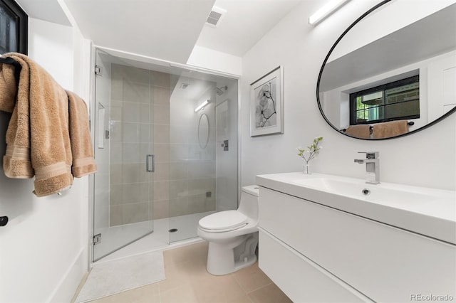 bathroom with vanity, toilet, a shower with shower door, and tile patterned flooring