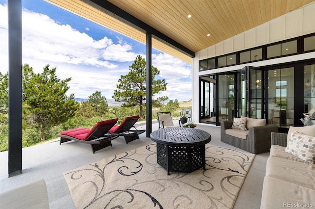 view of patio with an outdoor living space with a fire pit